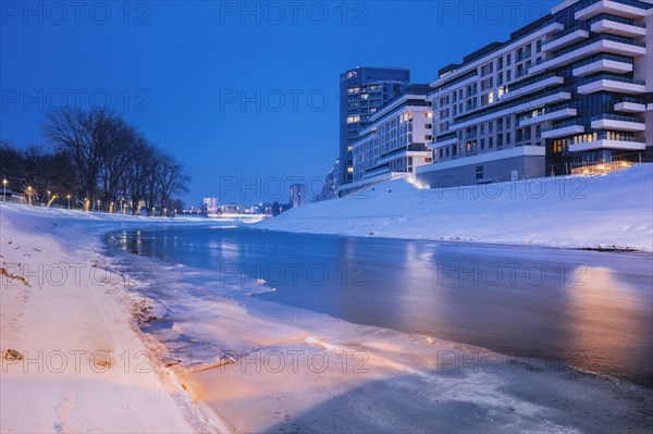 Poland, Subcarpathia, Rzeszow, Residential buildings at riverbank in winter