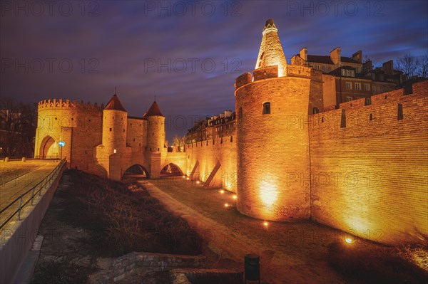 Poland, Masovia, Warsaw, Old City walls and barbican illuminated at night