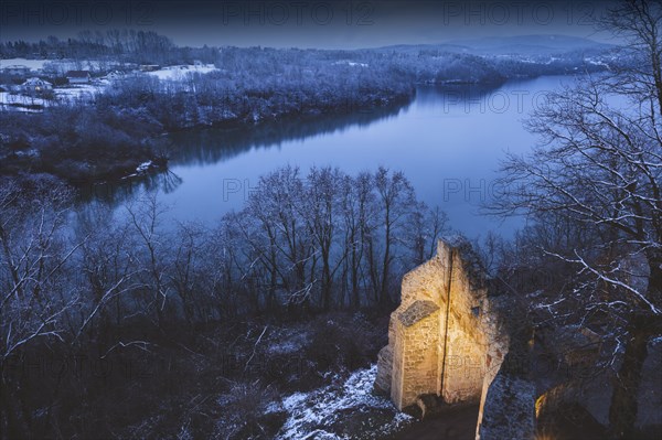 Poland, Lesser Poland, Dobczyce, Ruins of old castle in winter landscape by river