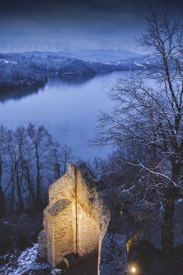 Poland, Lesser Poland, Dobczyce, Ruins of old castle in winter landscape by river