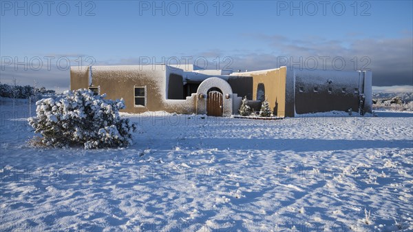 Usa, New Mexico, Santa Fe, Adobe style house covered with snow in winter