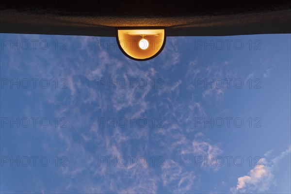 Low angle view of outdoor lamp on building against blue sky