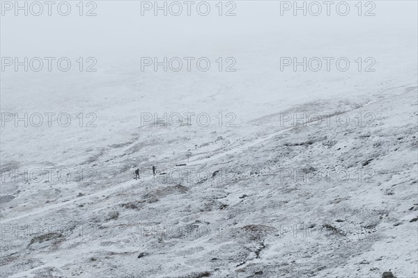 Australia, New South Wales, Snowy mountain landscape at Charlotte Pass in Kosciuszko National Park with incidental people on trail