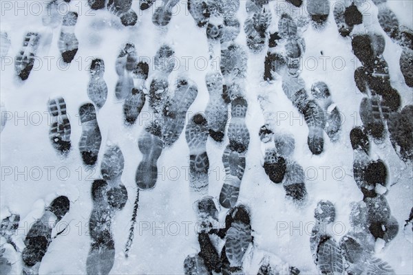 Australia, New South Wales, Kosciuszko National Park, Hiking shoes footprints on snowy trail in Kosciuszko National Park