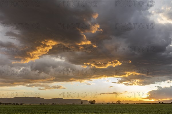 Usa, Idaho, Bellevue, Storm clouds over fields at sunset