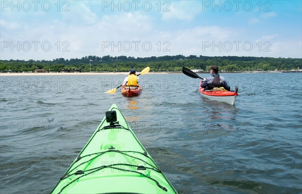 Usa, New York, Port Washington, People kayaking together on sea