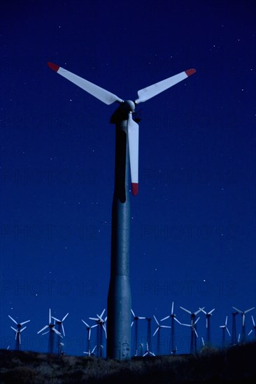 Wind turbines in landscape at night