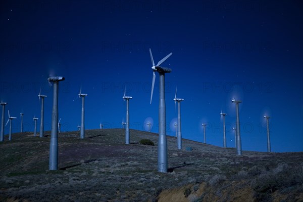 Wind turbines in landscape at night