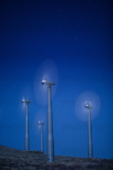 Wind turbines in landscape at night