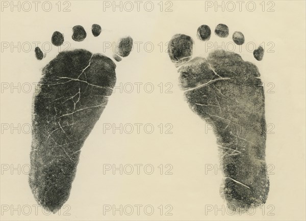 Footprint made with ink on paper of both feet new born infant girl