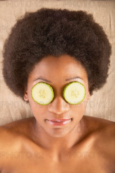 Woman with cucumber slices over eyes