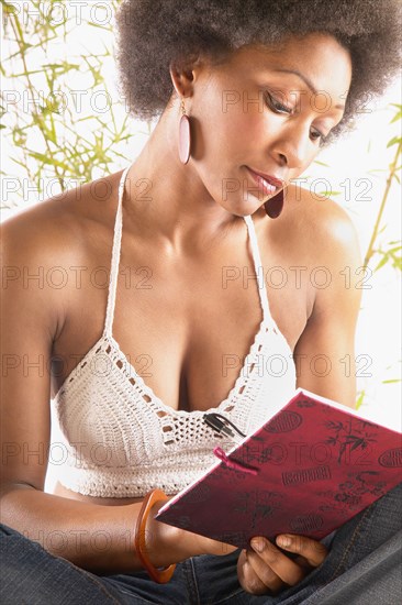 Young woman in crocheted top writing in journal