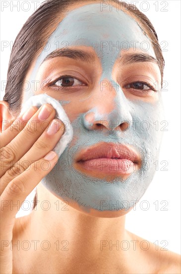 Close-up of woman removing blue facial mask