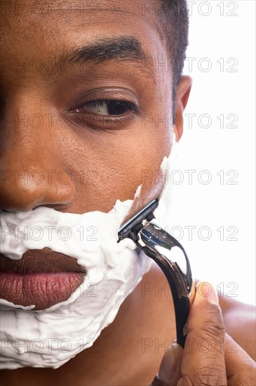 Close-up of man shaving