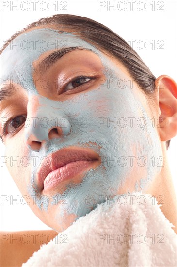 Close-up of woman removing blue facial mask