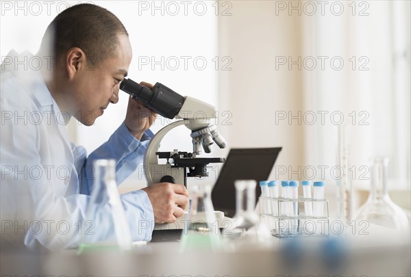 Korean scientist using microscope in laboratory