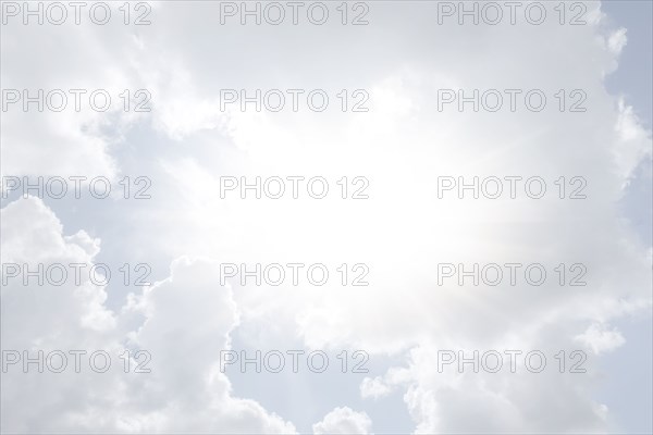 Sun shining through white clouds