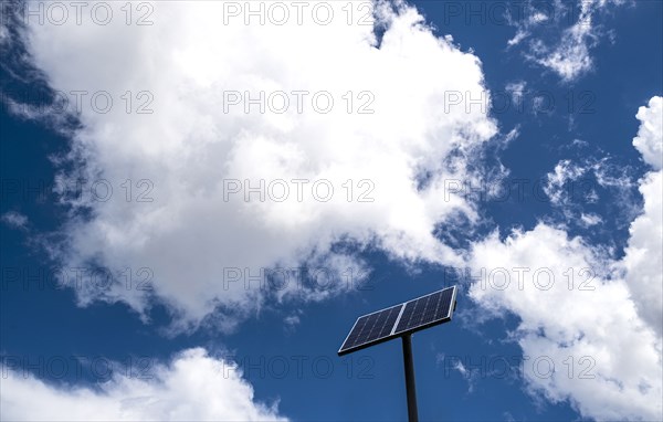 Solar panels against sky with white clouds