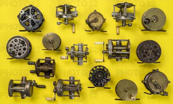 Vintage fishing reels on yellow background