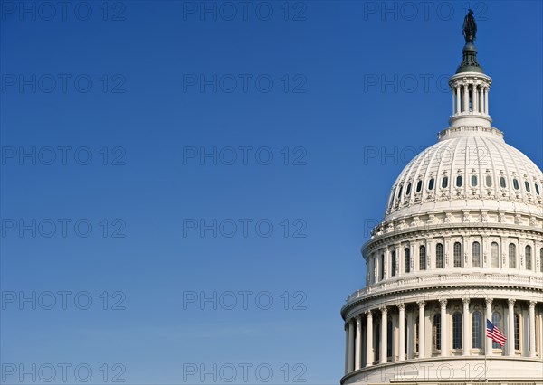 USA Capital building with flag against blue sky