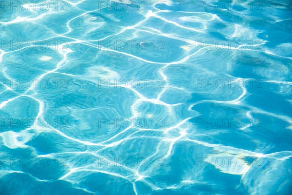 Surface of blue rippled water reflecting sunlight