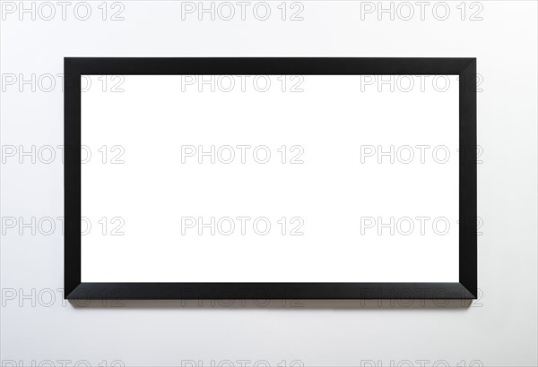 Empty black horizontal frame handing on white wall