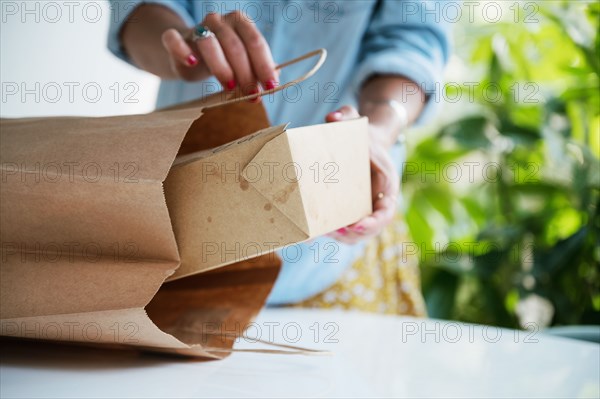 Close-up of woman unpacking take out food at home