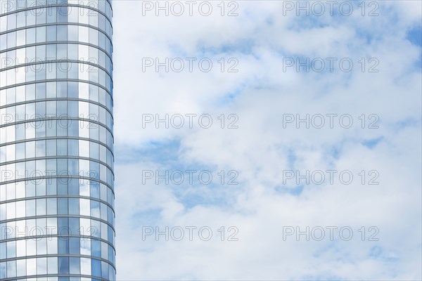 Tall modern building exterior and cloud covered sky
