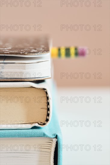 Close-up of stack of books with pencil