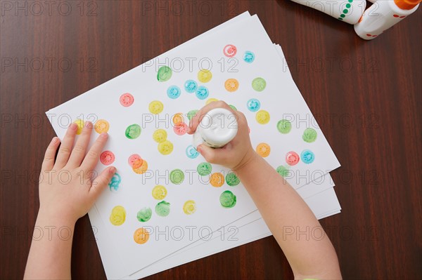 Overhead view of hands of girl painting