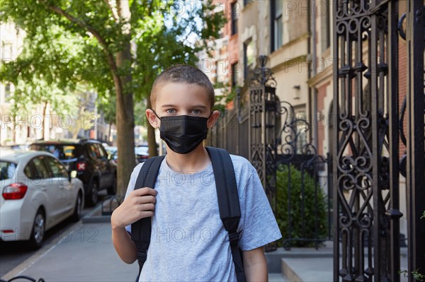 Portrait of Boy in face mask standing on sidewalk