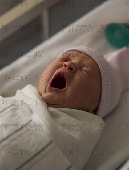 Yawning newborn baby girl