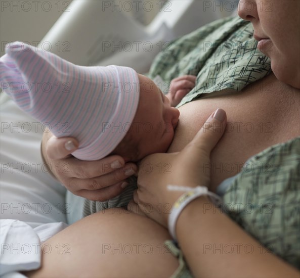 Mother breastfeeding newborn baby girl