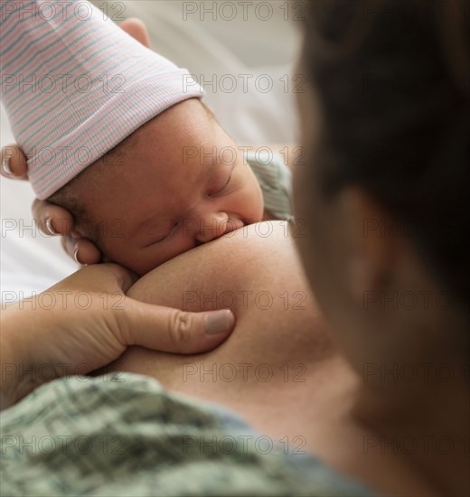 Mother breastfeeding newborn baby girl