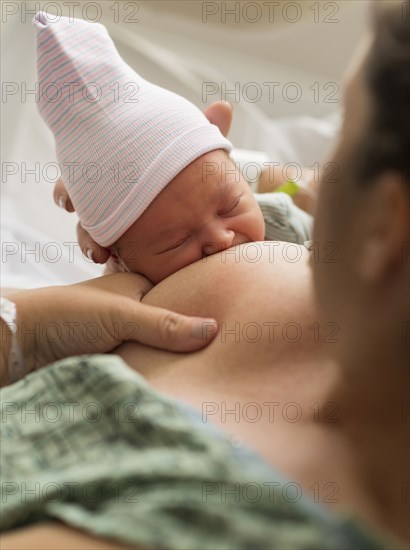 Mother breastfeeding newborn baby girl