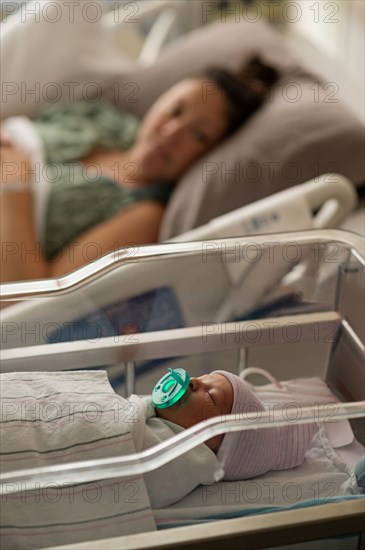 Mother lying with newborn baby girl