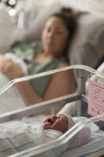 Mother lying with newborn baby girl