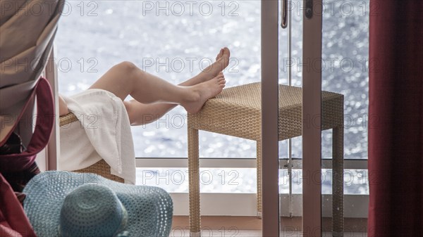 Woman relaxing on cruise ship balcony