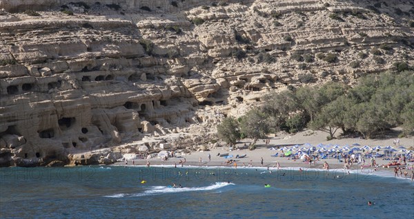 Tourists lying on beach and bathing in sea