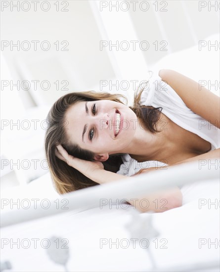 Portrait of smiling young woman lying on bed