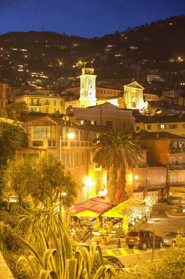 Palm trees and illuminated old town buildings