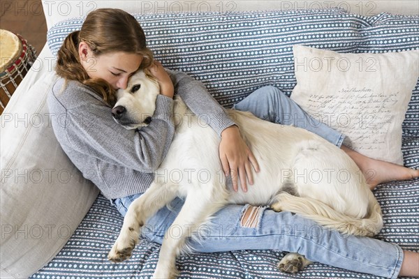 Girl embracing English Cream Golden Retriever