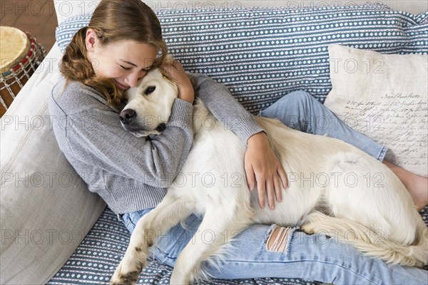 Girl embracing English Cream Golden Retriever