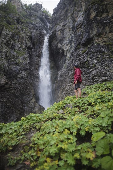 Hiker standing near waterfall