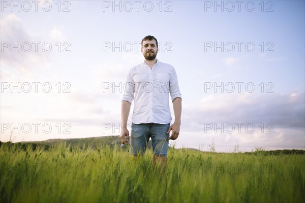 Mid adult man standing in agricultural field