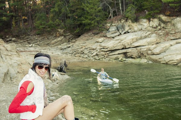 Woman near boyfriend rowing kayak in lake