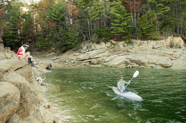 Woman watching boyfriend in kayak in lake