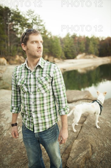 Man and dog standing near lake