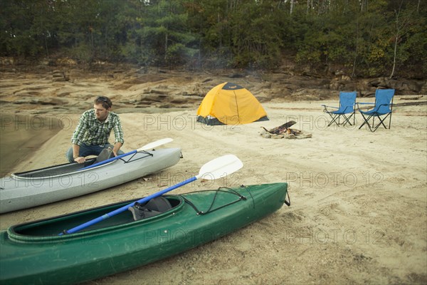 Man pushing kayak into lake