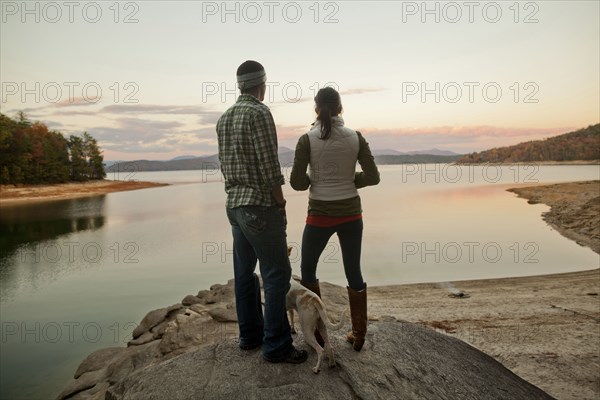 Couple and dog admiring remote lake